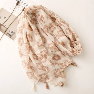Detail of floral printed scarf with intricate beige and brown tassel fringe edges
