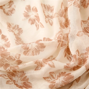 Detailed texture of off-white floral cotton scarf with soft ripples and floral print