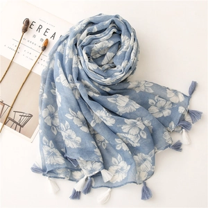 Detail of light blue floral cotton scarf with white hibiscus prints and fringe edges