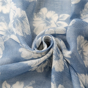 Detail of soft cotton linen fabric with white floral prints and light blue texture
