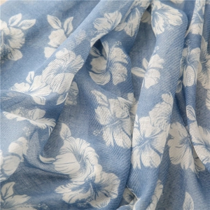 Detailed macro view of hibiscus floral print on lightweight blue cotton linen fabric scarf