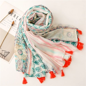 Close-up of lightweight floral scarf featuring orange tassels and paisley stripe patterns