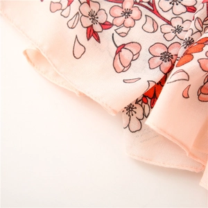 Detailansicht des rosa Kirschblütendrucks auf einem weichen, transparenten Schal