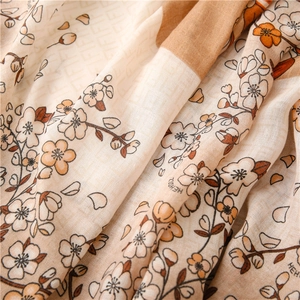 Detailaufnahme der Leinen-Schal-Textur mit Blumenmuster und Buchstaben-Print