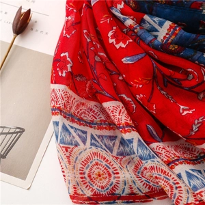 Detailed close-up of ethnic cotton scarf featuring red floral and blue geometric patterns