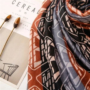 Artistic detail of geometric blue and orange scarf with a magazine in a cozy layout