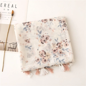Detailed macro shot of floral voile scarf with soft fringe tassels and pastel patterns