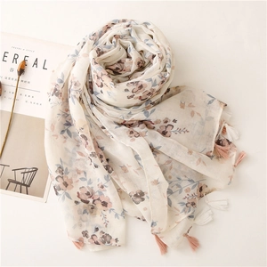 Detail of floral voile scarf featuring delicate prints and soft tassels for sun protection