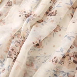 Detail of soft voile scarf with delicate floral print and light breathable texture