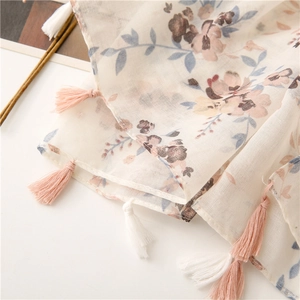 Detailed texture of cotton linen scarf with floral print and soft pink tassels