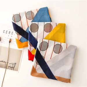 Detail of three folded scarves featuring geometric patterns with stripes and polka dots