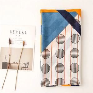 Detailed macro shot of color-blocked geometric pattern scarf with polka dots and stripes