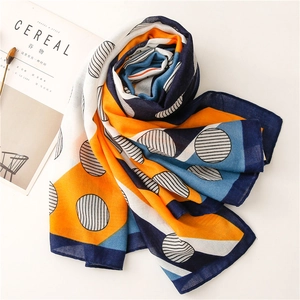 Detail view of cotton linen scarf with orange and blue geometric patterns and polka dots