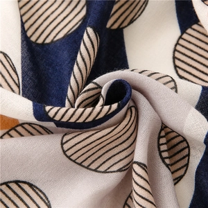 Macro detail of breathable cotton linen scarf with navy blue and beige geometric patterns