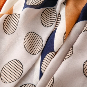 Detail shot of navy and orange geometric print linen scarf with soft fabric texture