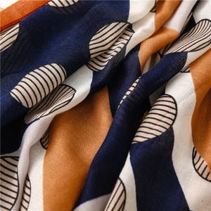 Macro detail of geometric color block scarf with navy dots and fine stripe texture