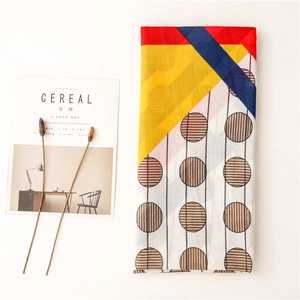 Minimalist layout of a long cotton linen scarf with geometric color block and polka dots