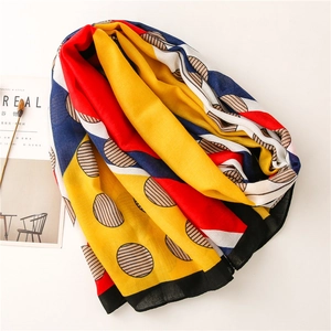 Detail of colorful geometric print scarf with polka dots and bold stripes pattern