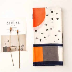 Detail of elegant orange and navy geometric print scarf with minimalist magazine layout