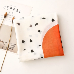 Close-up of lightweight cotton linen scarf texture with orange and black patterns