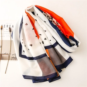Detail of color-block scarf with orange, blue, and white tones featuring black polka dots