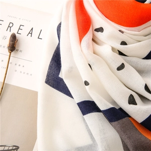 Detail of soft cotton linen scarf with orange and navy color blocks and black polka dots