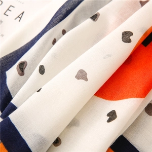 Close-up of lightweight cotton-linen scarf fabric with geometric print and polka dots