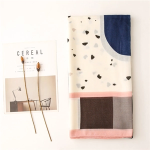 Detailed flat lay of geometric print scarf with blue and pink blocks on light background