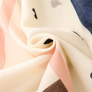Detailed texture of cotton linen scarf with heart patterns and striped edges