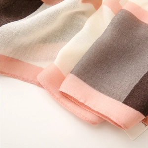 Detail of color-block plaid scarf showing fine texture and stitching on cotton-linen fabric