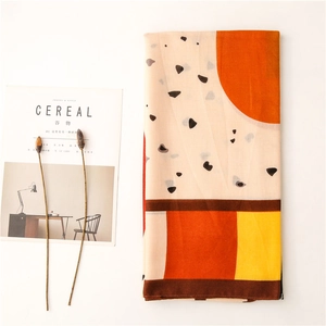 Detail of a geometric printed silk scarf with abstract block patterns and terrazzo dots