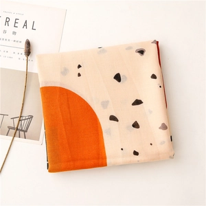 Detail of soft cotton-linen scarf with geometric orange semicircles and marble patterns