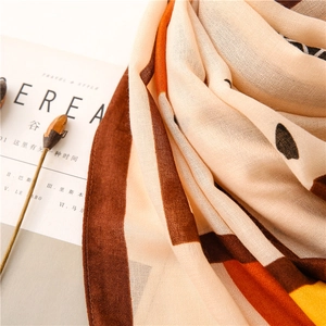 Close-up of geometric pattern autumn scarf with warm beige and orange tones