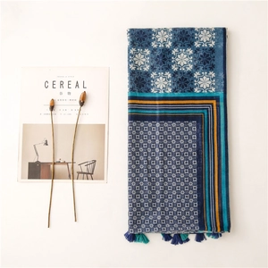 Moroccan style geometric print scarf with blue patterns and tassels on white background