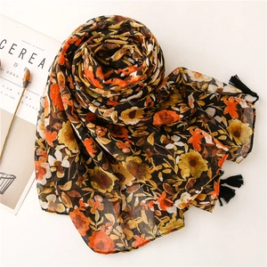 Detail of vintage floral pattern on chiffon scarf with black tassels and elegant styling