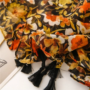 Close-up of vintage floral cotton scarf with orange flowers and black tassels