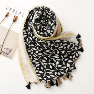 Detail of lightweight grape leaf print scarf with tassels and artistic magazine backdrop