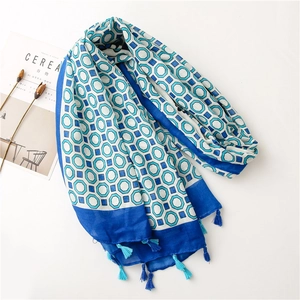 Detail of blue and white geometric pattern scarf with soft fringe edges and cotton texture