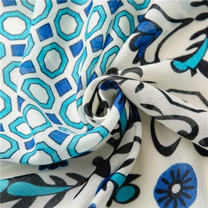 Close-up of floral linen shawl with blue geometric pattern and soft fabric texture