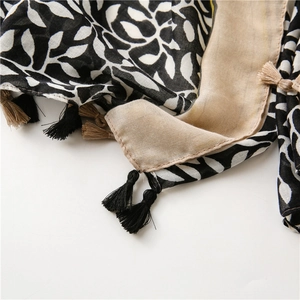 Detail of soft cotton linen scarf with grape leaf prints and woven tassels for summer