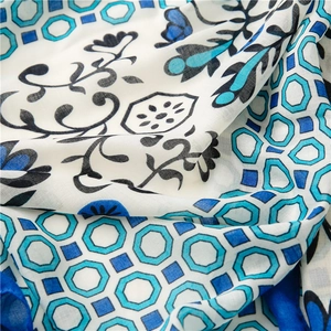 Close-up of soft floral cotton linen scarf with blue geometric patterns and fine texture