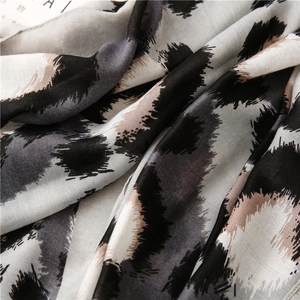 Macro shot of cotton linen scarf showing detailed leopard print and soft fabric texture