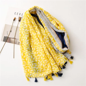 Detail of leaf pattern scarf with fringe tassels and ethnic border on white background