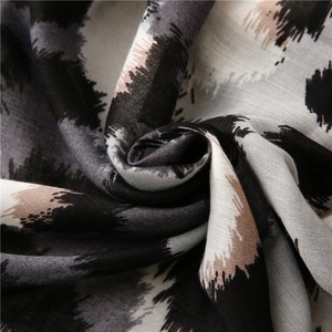 Detail of leopard print cotton linen scarf showing soft fabric texture and beige grey pattern