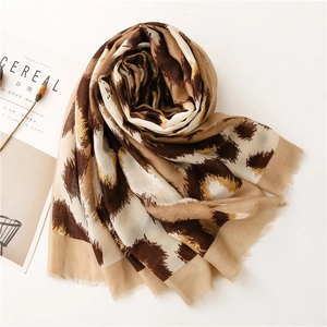 Close-up of lightweight leopard print scarf with fringe edges and cotton linen texture