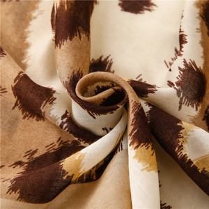 Detail of leopard print scarf fabric showing soft cotton linen texture and brown patterns