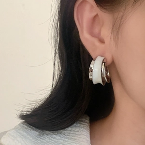 French vintage silver C-shaped earrings with white enamel inlay worn by a model
