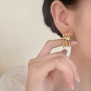 Minimalist matte gold teardrop fringe stud earrings shown on model for elegant daily wear