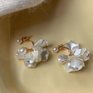 Detailed macro view of French vintage floral pearl earrings with golden metal base
