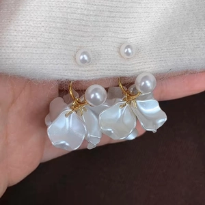Detail of French vintage pearl earrings with frosted acrylic petals and gold hoops